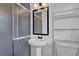 Bathroom featuring pedestal sink, shower, and wire shelving at 5185 Twin Oak Ne Dr, Woodstock, GA 30188