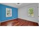 Bedroom featuring hardwood floors, blue accent wall and natural light at 5185 Twin Oak Ne Dr, Woodstock, GA 30188