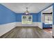 Dining area with wood floors, wainscoting, blue walls, and view to the front yard at 5185 Twin Oak Ne Dr, Woodstock, GA 30188