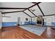 Spacious living room with a stone fireplace, hardwood floors, beamed ceiling, and an attractive ceiling fan at 5185 Twin Oak Ne Dr, Woodstock, GA 30188