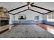 Open-concept living room with fireplace, exposed beams, and wood floors at 5185 Twin Oak Ne Dr, Woodstock, GA 30188