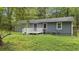 Backyard featuring a small deck and gray home with gray siding surrounded by overgrown grass at 2412 Forrest Park Se Rd, Atlanta, GA 30315