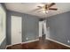 Bedroom featuring hardwood floors, neutral gray walls, ceiling fan, and doors leading to other rooms at 2412 Forrest Park Se Rd, Atlanta, GA 30315