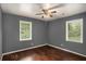 Bedroom with hardwood floors, ceiling fan, neutral gray walls, and natural light coming through the windows at 2412 Forrest Park Se Rd, Atlanta, GA 30315