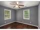 Bedroom featuring hardwood floors, ceiling fan, and two windows providing natural light at 2412 Forrest Park Se Rd, Atlanta, GA 30315