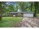 Charming single-story brick home featuring a two-car garage and a lawn partially covered in greenery at 2412 Forrest Park Se Rd, Atlanta, GA 30315