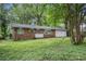 Inviting single-story brick home with a two-car garage, shaded by mature trees and a lawn with greenery at 2412 Forrest Park Se Rd, Atlanta, GA 30315
