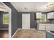 View of kitchen with white cabinets, gray backsplash, and dining area, featuring neutral gray walls and floors at 2412 Forrest Park Se Rd, Atlanta, GA 30315