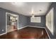 Light-filled living room with hardwood floors, neutral paint, and an open transition to the adjacent kitchen at 2412 Forrest Park Se Rd, Atlanta, GA 30315