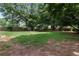 Spacious backyard with lush green grass, mature trees, a wooden fence, and a storage shed at 2502 Kerry Ne Ct, Marietta, GA 30066