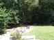 Lush backyard featuring vibrant flowers and a tranquil wooded area, perfect for relaxation at 4019 Hickory Fairway Dr, Woodstock, GA 30188