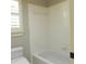 White tiled shower and tub next to a window at 4019 Hickory Fairway Dr, Woodstock, GA 30188