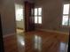Bedroom featuring hardwood floors, plantation shutters, and a view into the Primary bathroom at 4019 Hickory Fairway Dr, Woodstock, GA 30188