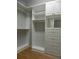 Bright walk-in closet with white shelving, drawers, gold hardware, and a mirrored vanity, providing ample storage space at 4019 Hickory Fairway Dr, Woodstock, GA 30188