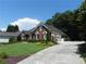 Beautiful red brick home with well-maintained lawn, mature landscaping, and attached garage via long driveway at 4019 Hickory Fairway Dr, Woodstock, GA 30188