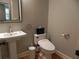 Compact powder room with pedestal sink, modern toilet, and decorative mirror at 4019 Hickory Fairway Dr, Woodstock, GA 30188
