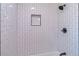 A renovated shower with modern shower head, built-in shelf, and white subway tile at 810 Parkway Se Dr, Smyrna, GA 30080
