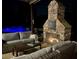 Cozy patio seating area with a stone fireplace, perfect for evening relaxation by the glowing pool at 216 Slate Dr, Buford, GA 30518