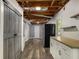 Finished basement area with wood flooring, open ceiling, barn door and kitchen appliances at 1200 Taylor Oaks Dr, Roswell, GA 30076