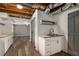 Basement kitchenette area with wood flooring, barn door, open ceiling, sink and storage at 1200 Taylor Oaks Dr, Roswell, GA 30076