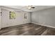 Spacious bedroom featuring hardwood floors, a ceiling fan, and two large windows for natural light at 1200 Taylor Oaks Dr, Roswell, GA 30076