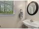 Powder room featuring pedestal sink, round mirror and window with blinds at 1200 Taylor Oaks Dr, Roswell, GA 30076