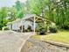Exterior view featuring a carport with lush landscaping and mature trees at 4437 Janice Dr, Snellville, GA 30039