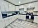Bright kitchen featuring white cabinets, black countertops, and stainless steel appliances at 4437 Janice Dr, Snellville, GA 30039