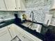 Modern kitchen sink with granite countertops and stylish backsplash at 4437 Janice Dr, Snellville, GA 30039