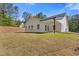 A backyard with a manicured lawn, wood beam covered porch, and white siding at 1408 Campbell Rd, Covington, GA 30014