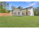 A shot of the backyard showing the covered porch of the modern home and the green lawn at 1408 Campbell Rd, Covington, GA 30014