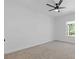A bedroom with white walls, plush carpet, a ceiling fan, and a bright window at 1408 Campbell Rd, Covington, GA 30014