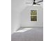 Bedroom featuring neutral carpet, white walls and trim, a modern ceiling fan, and a window with a view of the wooded backyard at 1408 Campbell Rd, Covington, GA 30014