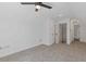 Carpeted bedroom featuring white walls, modern ceiling fan, and double doors leading to the bathroom and closet at 1408 Campbell Rd, Covington, GA 30014
