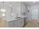 Bright, modern kitchen features white cabinets, stainless steel appliances, quartz countertops, and hardwood floors at 1408 Campbell Rd, Covington, GA 30014