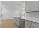 Modern kitchen featuring white cabinets, stainless steel appliances, quartz countertops, and hardwood floors at 1408 Campbell Rd, Covington, GA 30014