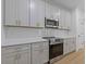 Modern kitchen features white cabinets, stainless steel appliances, quartz countertops, and hardwood floors at 1408 Campbell Rd, Covington, GA 30014