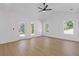 Bright living room features wood floors, white walls, lots of windows, and a ceiling fan at 1408 Campbell Rd, Covington, GA 30014