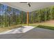 Covered patio with wood beam, concrete flooring and beautiful backyard view at 1408 Campbell Rd, Covington, GA 30014