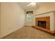 Living room featuring a fireplace with brick hearth, neutral carpet and a ceiling fan at 160 Vinnys Way, Covington, GA 30014