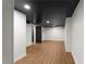 Finished basement with wood-look floors, modern ceiling tiles, and white walls at 3984 Earney Rd, Woodstock, GA 30188