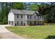 Stunning two-story white home featuring an attached three car garage and inviting front porch at 3984 Earney Rd, Woodstock, GA 30188