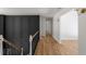 Hallway with views of the black wall paneling, hardwood floors, and white walls at 3984 Earney Rd, Woodstock, GA 30188