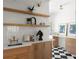 Stylish laundry room featuring wooden floating shelves and a chic black and white tiled floor at 3984 Earney Rd, Woodstock, GA 30188