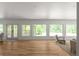 View of the living room with hardwood floors and multiple windows overlooking the spacious porch at 3984 Earney Rd, Woodstock, GA 30188