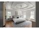 Main bedroom with tray ceilings, hardwood floors, and multiple windows for natural light at 3984 Earney Rd, Woodstock, GA 30188