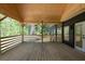 View of the spacious wooden porch with wooden railings and exposed beams, and entrance to the home at 3984 Earney Rd, Woodstock, GA 30188