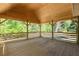 View of the spacious wooden porch with wooden railings and exposed beams, overlooking the outdoors at 3984 Earney Rd, Woodstock, GA 30188