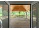 View of the spacious wooden porch with wooden railings and exposed beams, looking out from the doorway at 3984 Earney Rd, Woodstock, GA 30188