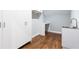 Modern closet space with storage cabinets, a sink, light blue walls, and dark hardwood floors at 4101 Brookview Se Dr, Atlanta, GA 30339